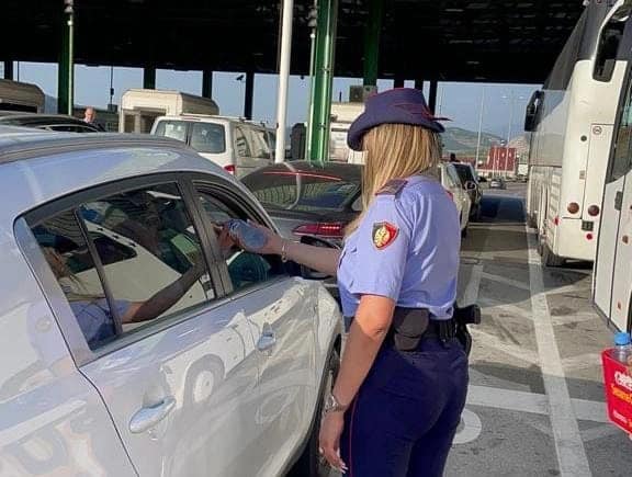 Policia shqiptare shpërndan ujë të ftohtë për udhëtarët në pikën kufitare Morinë