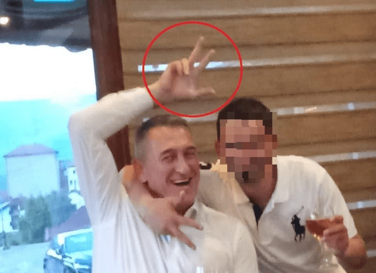 Rashiq feston duke i ngritur tre gishtat, gjatë një ndeje në Shtërpcë